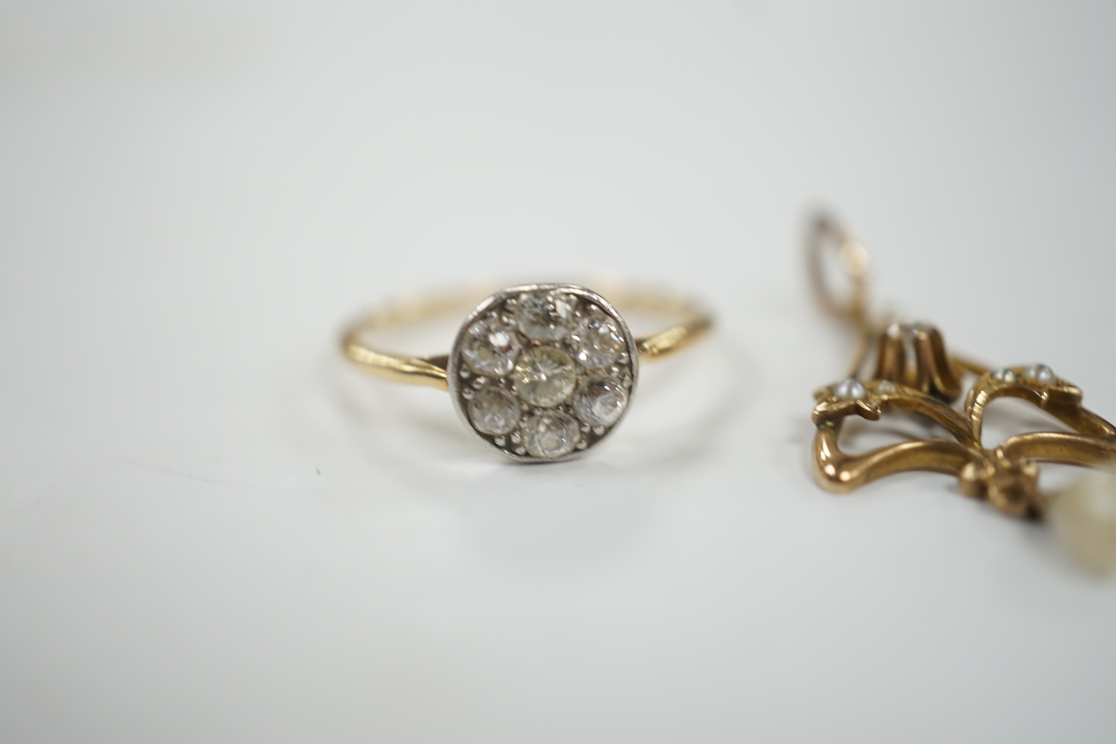 A yellow metal and seven stone diamond set circular cluster ring, size M/N, together with a small Edwardian yellow metal, diamond and seed pearl set drop pendant, gross weight 3 grams.